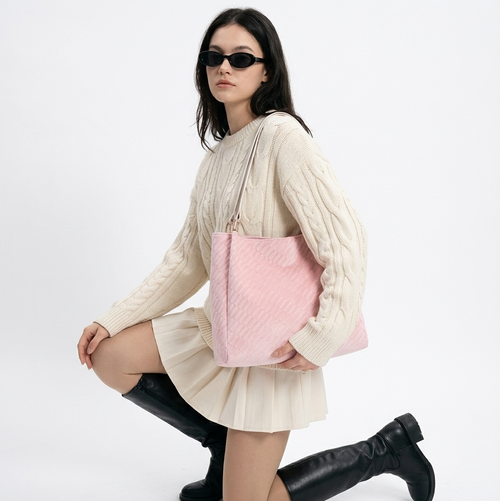 The Odette Everyday Shopper in pink woven fabric on the shoulder of a model in a cream knit